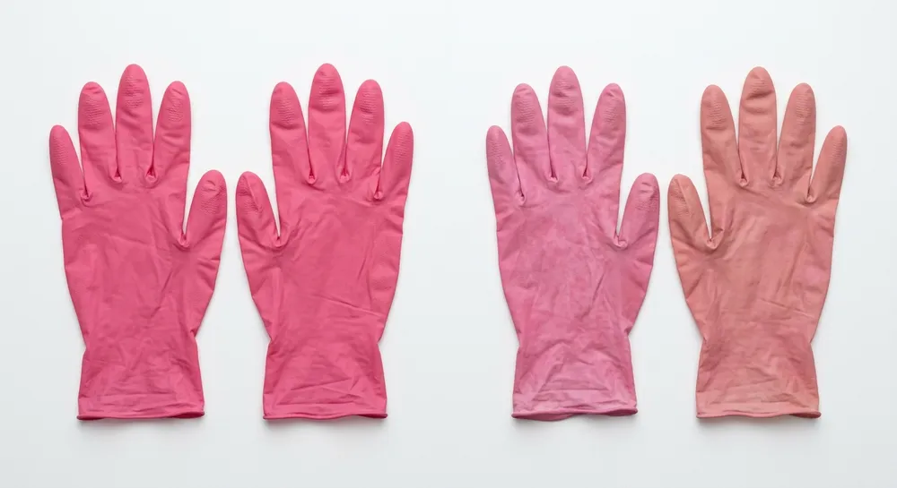 Side-by-side comparison of pink nitrile gloves from two production batches showing color variation